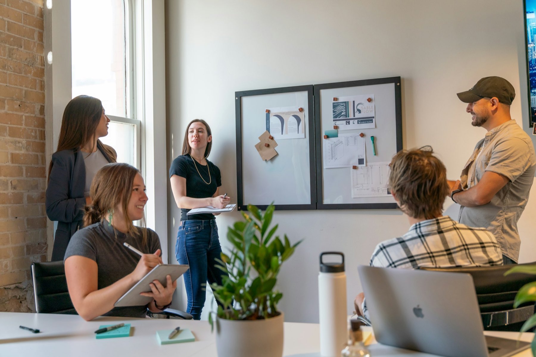 A small team and a client in a sunlit office, mid-conversation
