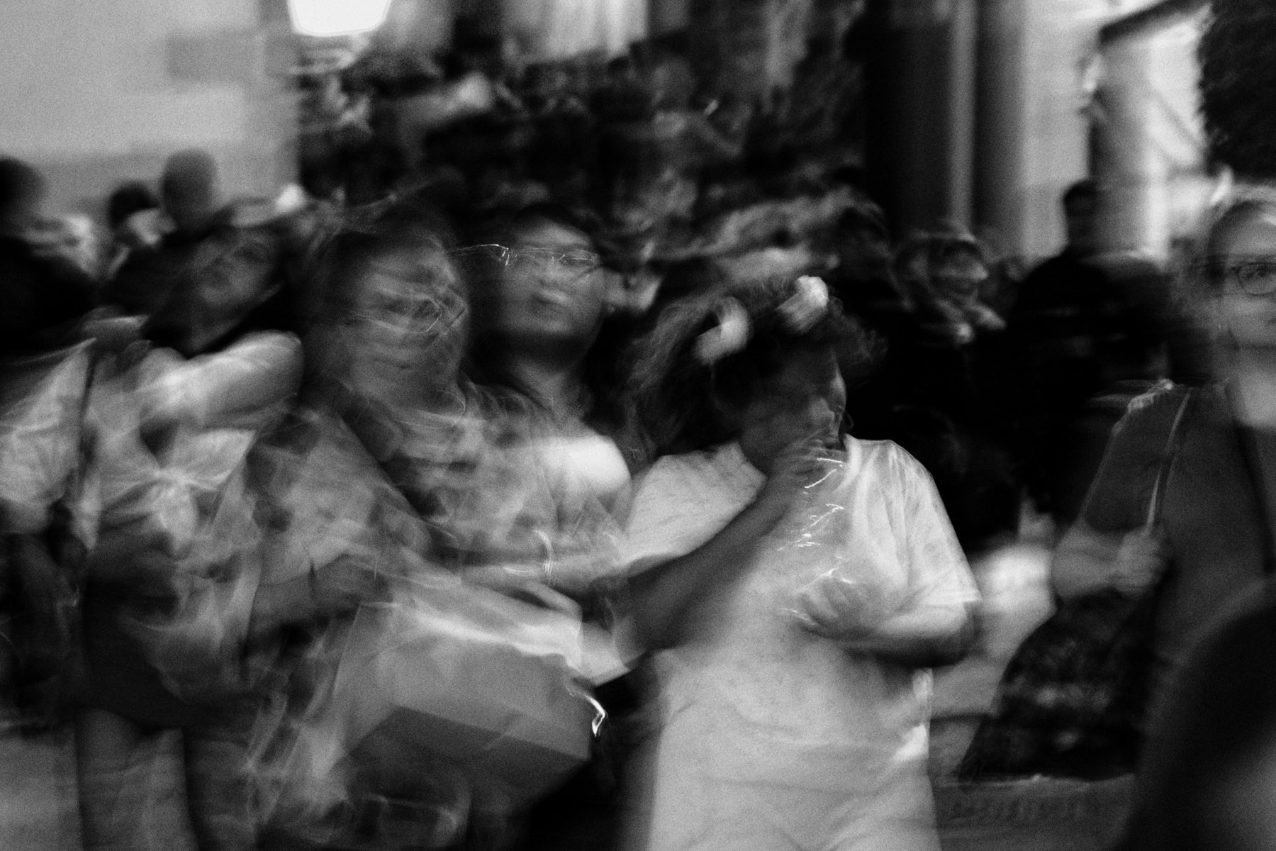 A crowd walking a city street in the morning, out of focus
