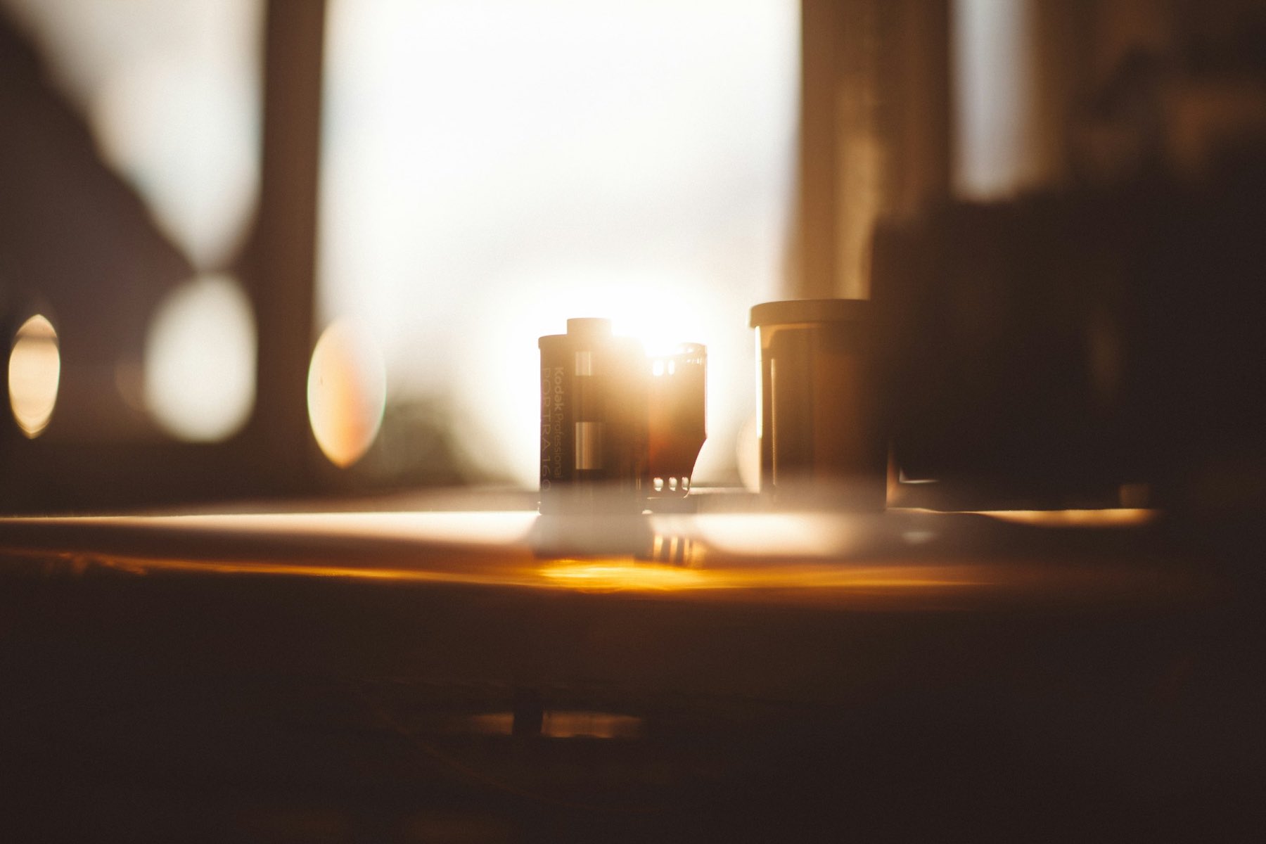 Low gold light across two cups on a dark table